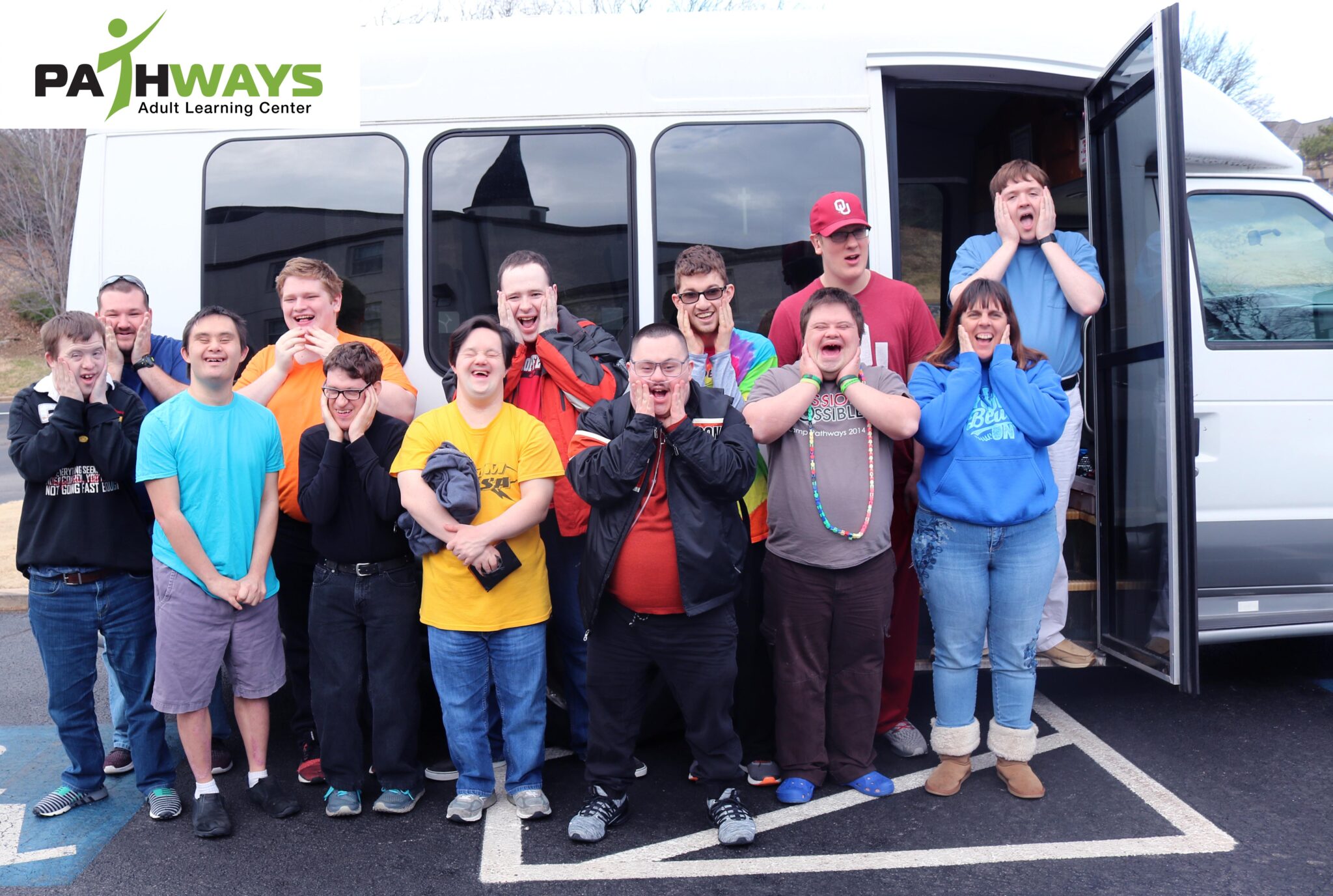 13 students excited in front of our new shuttle bus!