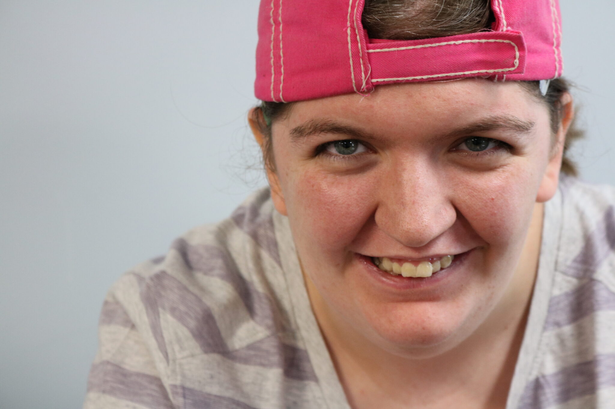 A female student wearing a pink ballcap being worn backwards.