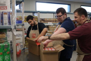 A group of students packing food into a box