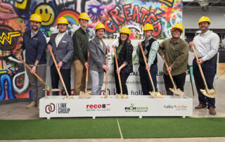 Pathways Executive director Monique Scraper with Tim Cargile, Pathways Board Member, Pathways students Philip Otto and Michael Eskridge, and a member from Recco Construction wearing hard hats and using shovels to ceremonially turn the dirt at the ground breaking ceremony for our new building.