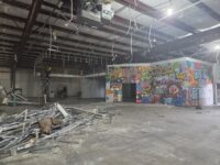 An image showing a wall that is in the process of being torn down.