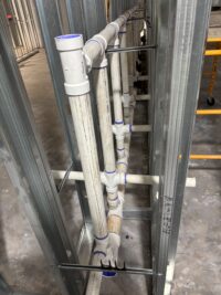 An image of PVC pipe in-between metal framed walls.